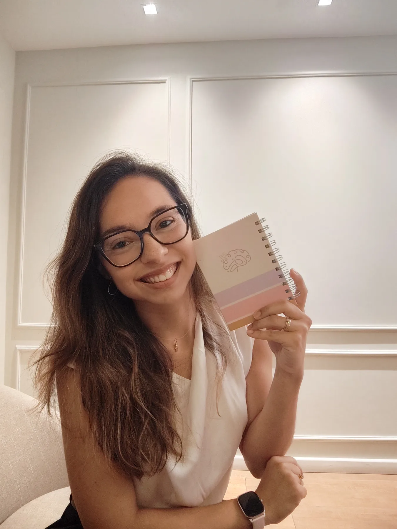 Juliane Ishimaru com caderno de sua identidade profissional